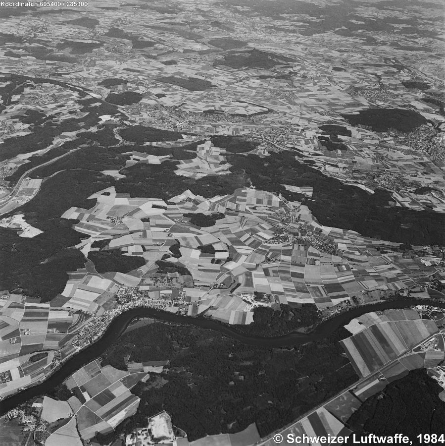 Aufnahme 1984; vorne links am Rhein das deutsche Dorf Büsingen; Dörflingen gegen die Bildmitte; im Hintergrund Bietingen, Randegg, Gottmadingen